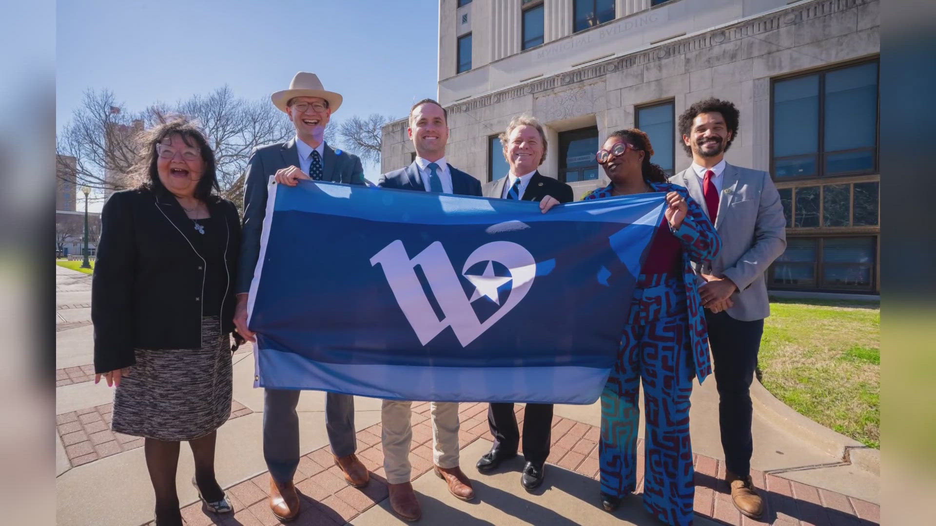 City Council Members stood outside of City Hall to take photos with the new flag.